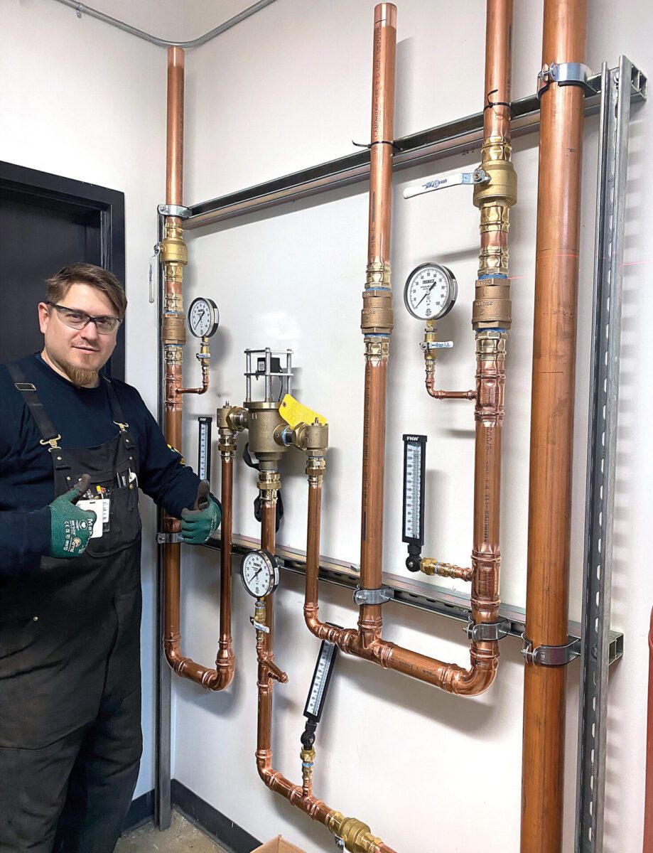 Man standing next to piping 